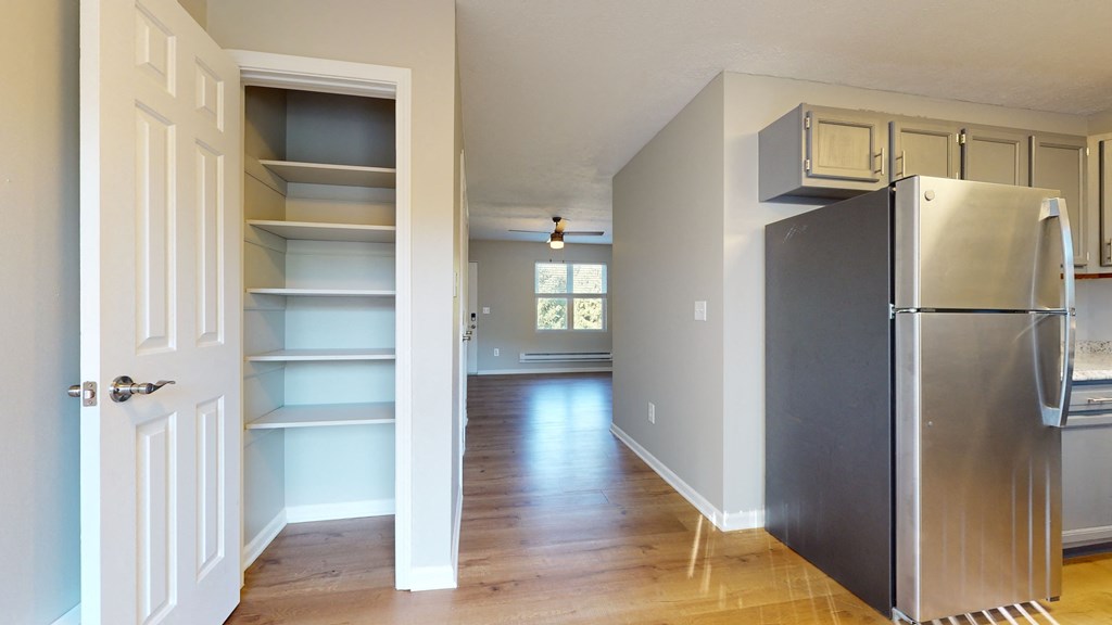 a renovated kitchen with a stainless steel refrigerator and shelves