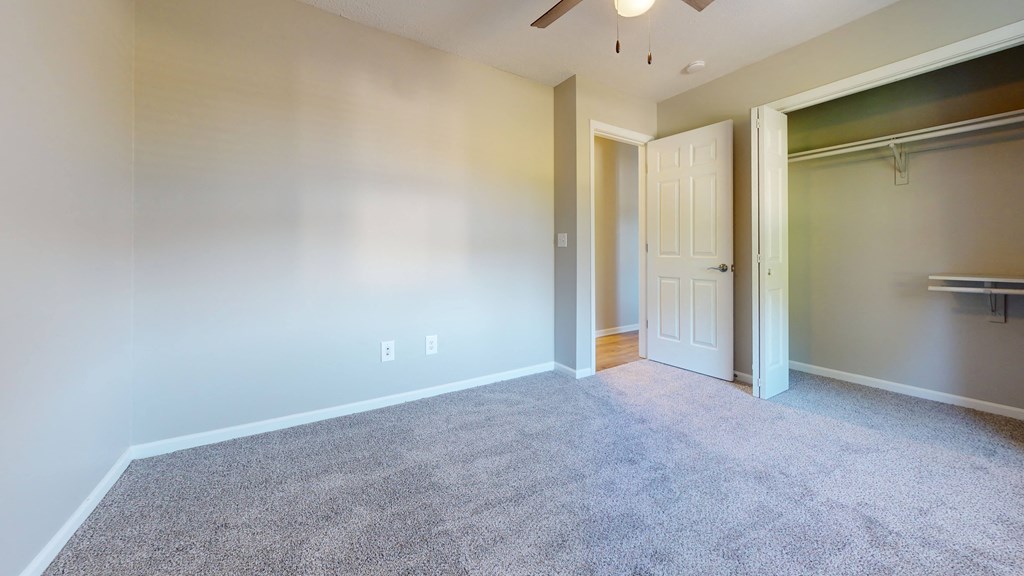 an empty room with a closet and a door to a closet