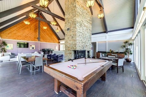 a pool table in a large room with a stone fireplace at Summit at Keystone, Indianapolis, IN 46220