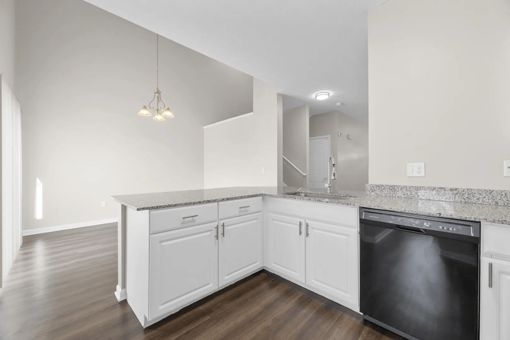 a kitchen with white cabinets and a black dishwasher at Traditions at Slate Ridge, Ohio, 43068