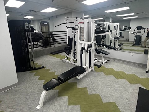 A gym with a variety of equipment including a leg press machine.