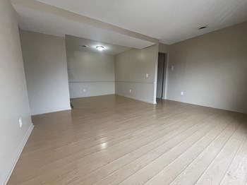 an empty living room with a hardwood floor - Photo Gallery 16