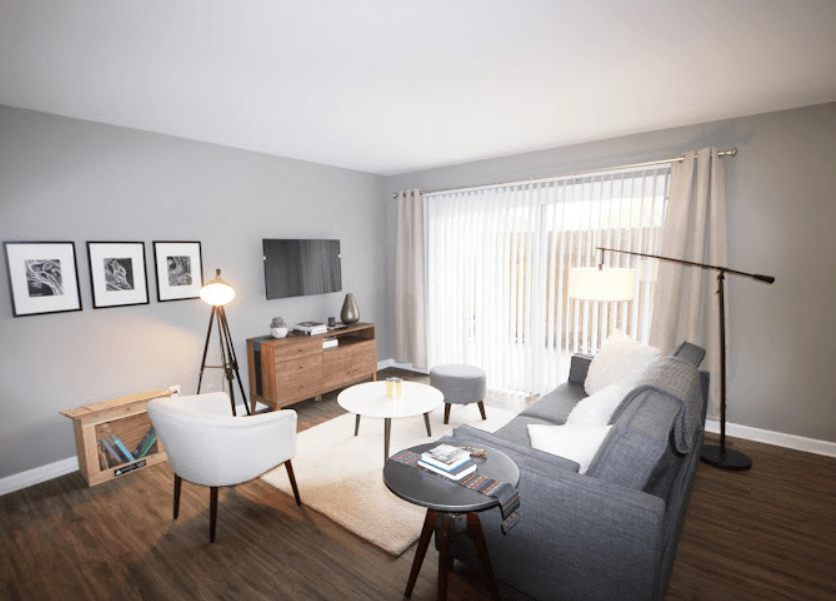 a living room with a couch and chairs and a tv