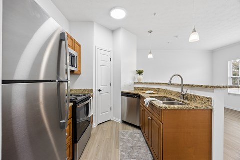 A modern kitchen with a stainless steel refrigerator and wooden cabinets.