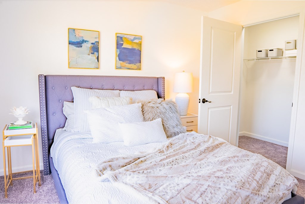 a bedroom with a bed and two paintings on the wall