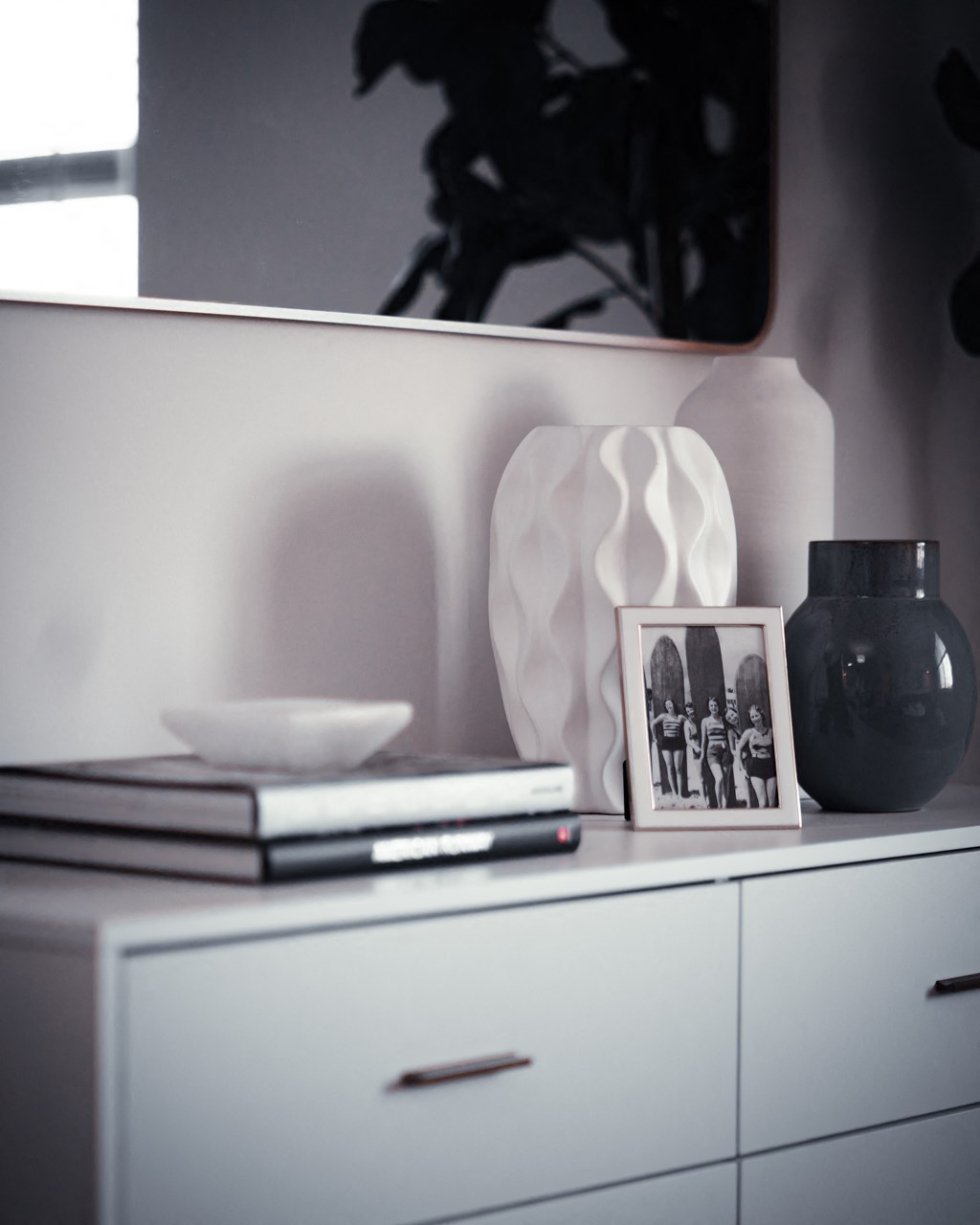 a white dresser with a vase and a picture on top of it