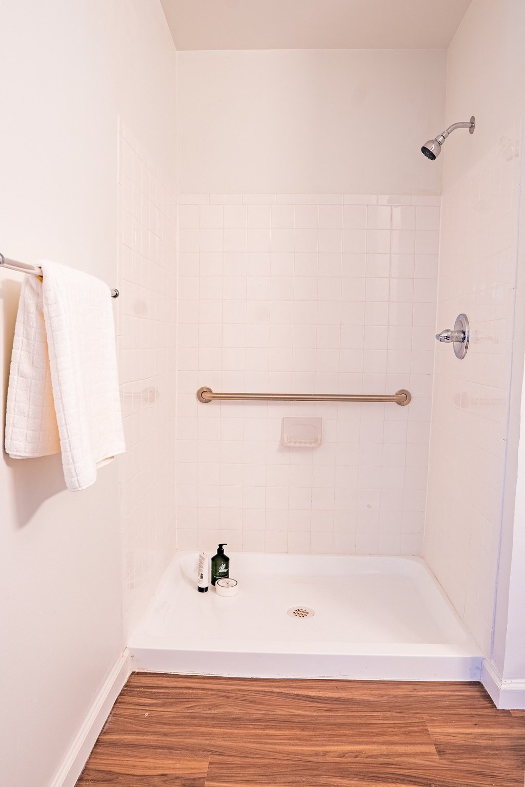 a small bathroom with a shower and a towel rack and a tub