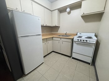 an empty kitchen with a white stove and refrigerator - Photo Gallery 3