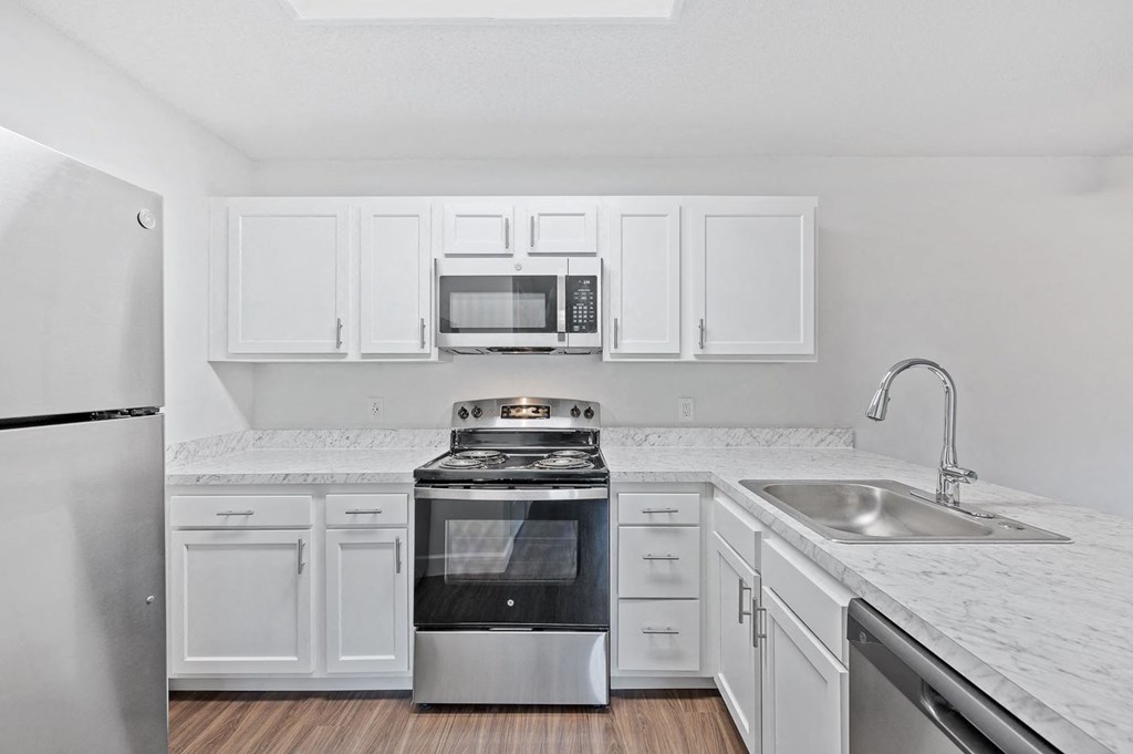 a kitchen with white cabinets and stainless steel appliances