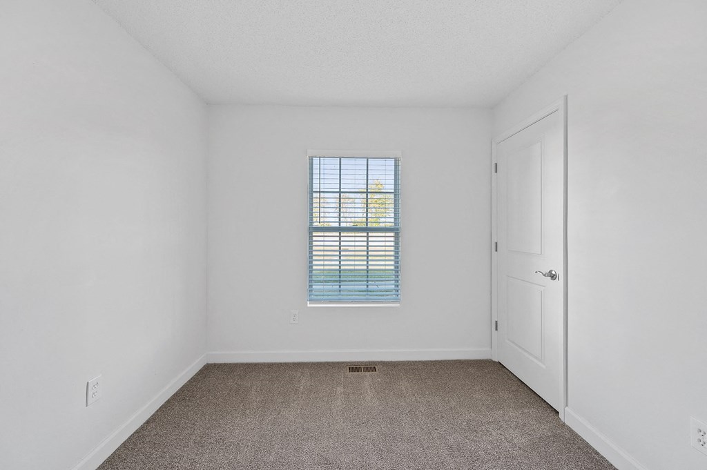 an empty room with a window and a door