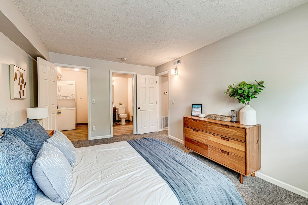 A bedroom with a bed, dresser, and mirror. at The Apex, Cincinnati, 45239