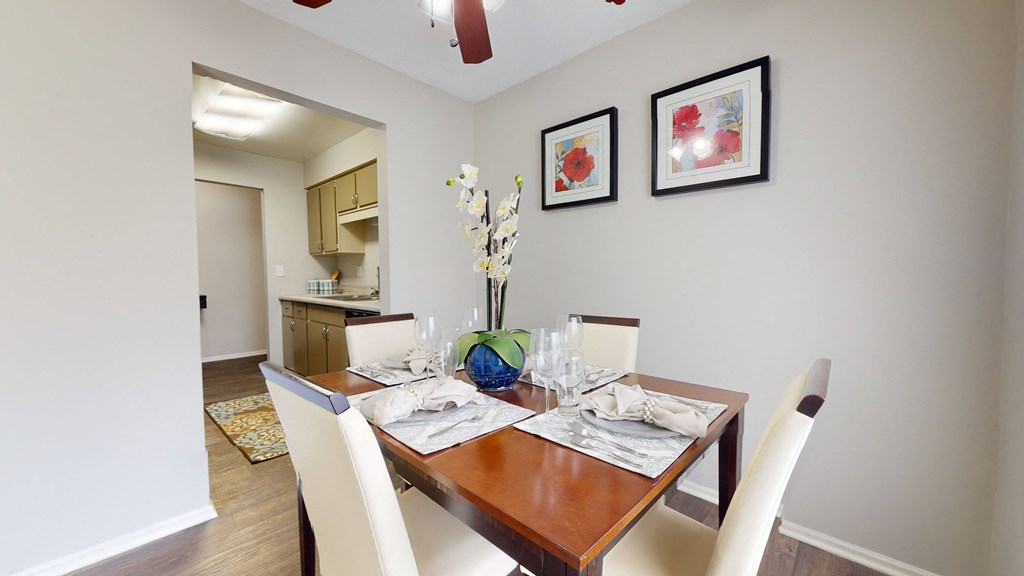 Dining room with a wooden table and white chairs at Summit at Keystone, Indianapolis Indiana