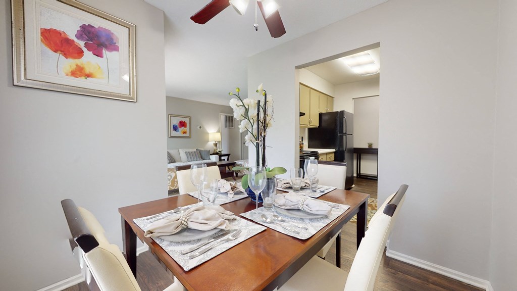 Dining room table with white chairs and a ceiling fan at Summit at Keystone, Indianapolis, 46220
