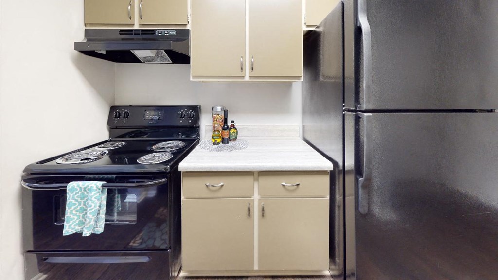 Kitchen with a stove top oven next to a refrigerator Kitchen with a stove top oven next to a refrigerator at Summit at Keystone, Indianapolis Indiana