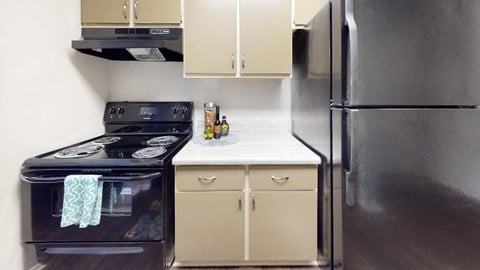a kitchen with a stove top oven next to a refrigerator at Summit at Keystone, Indianapolis Indiana