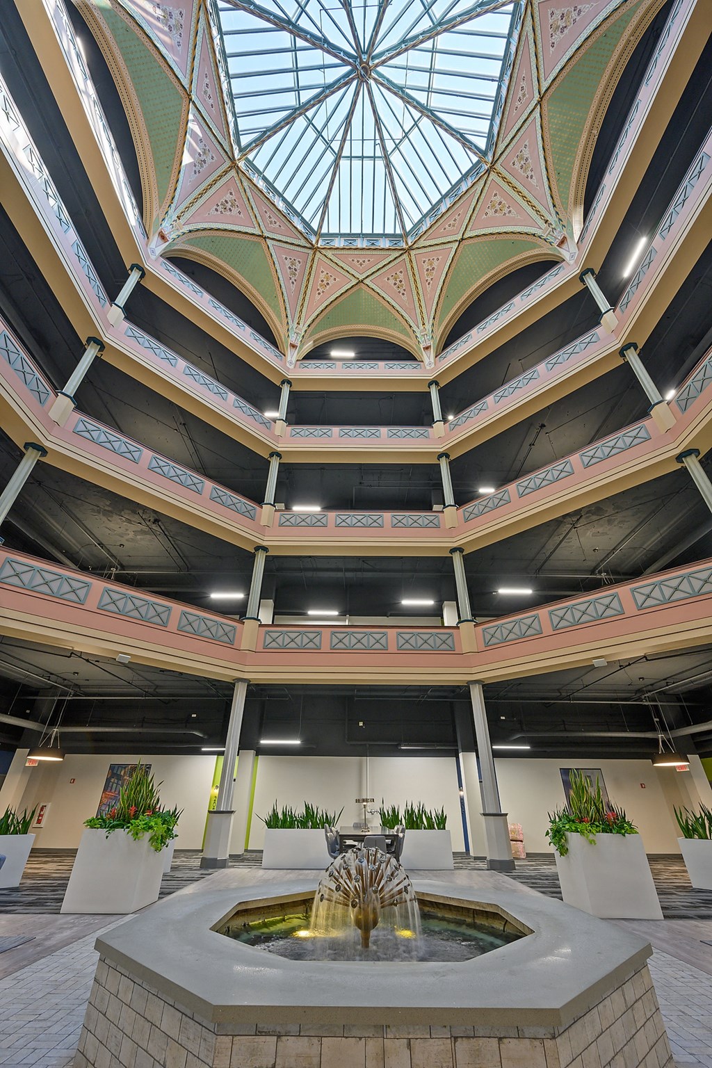 the fountain in the center of a large building with a glass ceiling