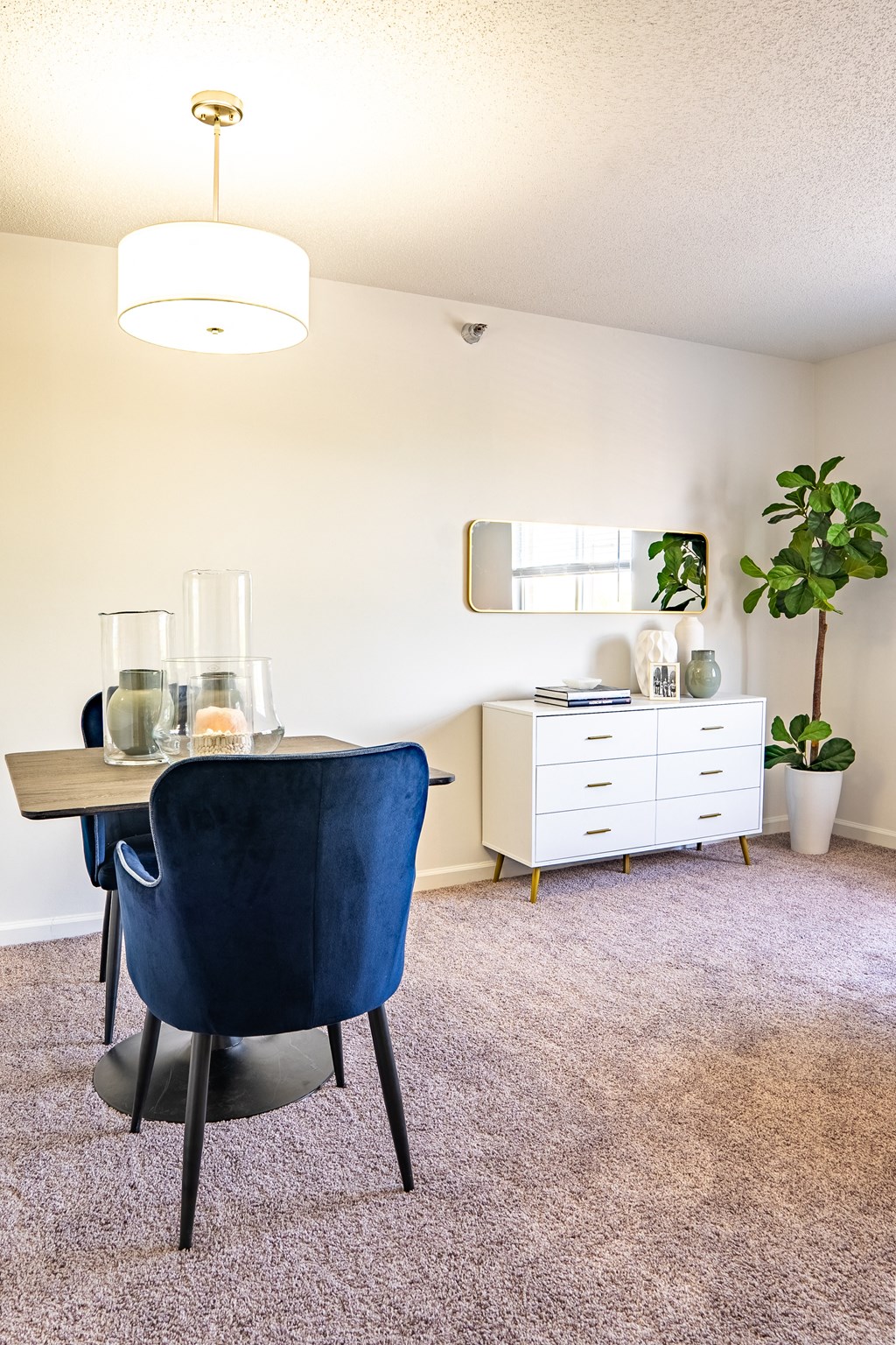 a dining room with a table and chairs and a mirror on the wall
