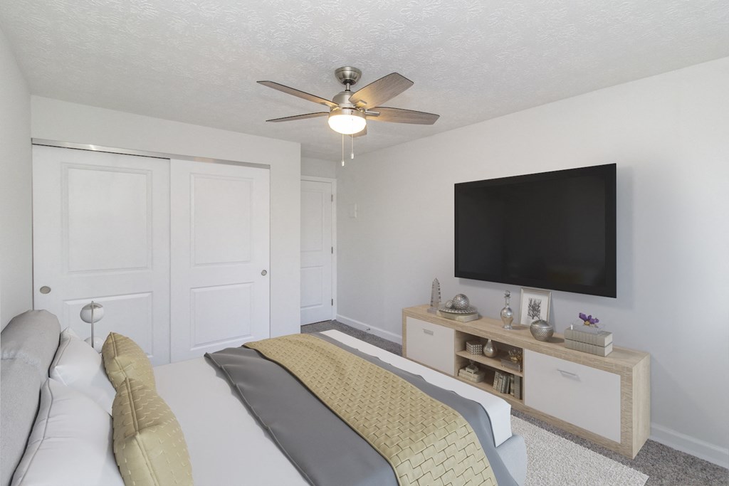 a bedroom with a bed and a ceiling fan and a tv