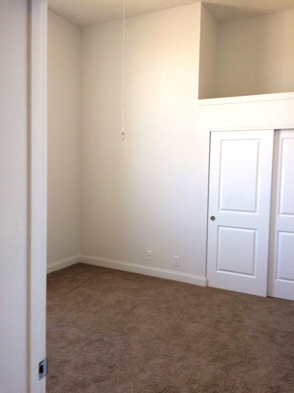 an empty room with white doors and a carpet