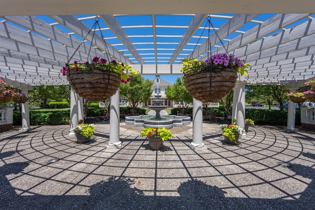 a courtyard with two hanging baskets of flowers and a fountain at Bishops Gate, Cincinnati