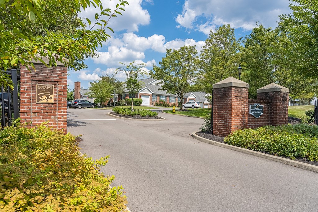 an empty street in a neighborhood with brick pillars and a gate at Bishops Gate, Ohio, 45249