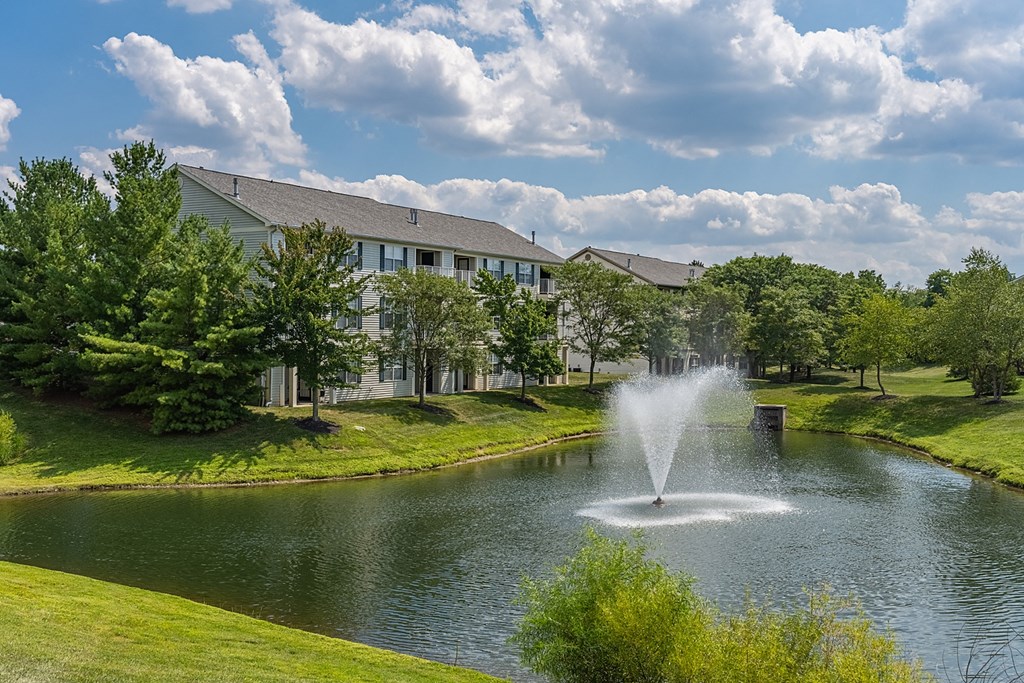 a fountain in the pond with a building in the background at Bishops Gate, Cincinnati