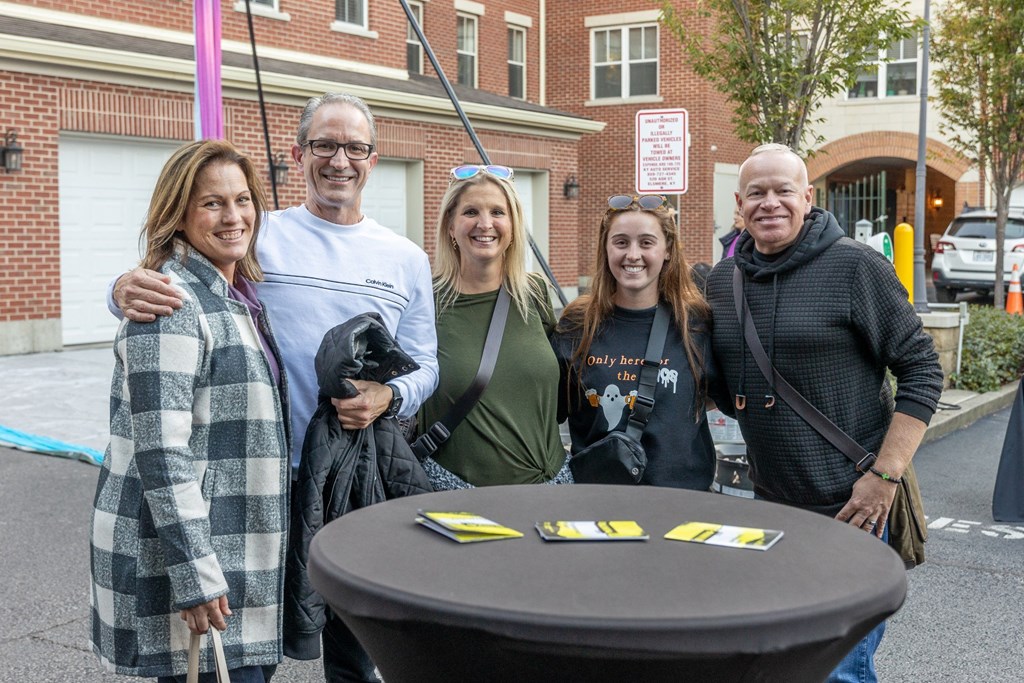 a group of people standing around a table