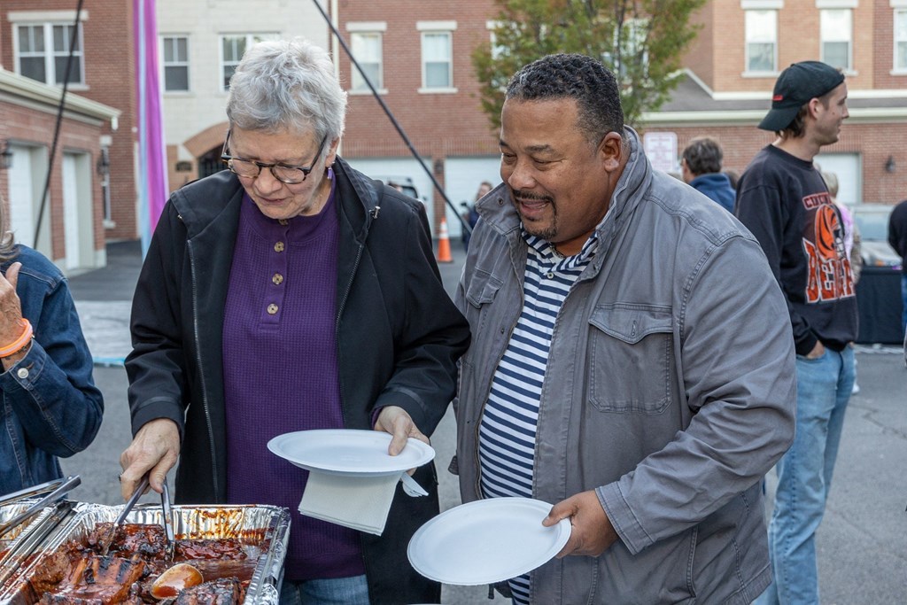 a man and a woman serving food at a food stand