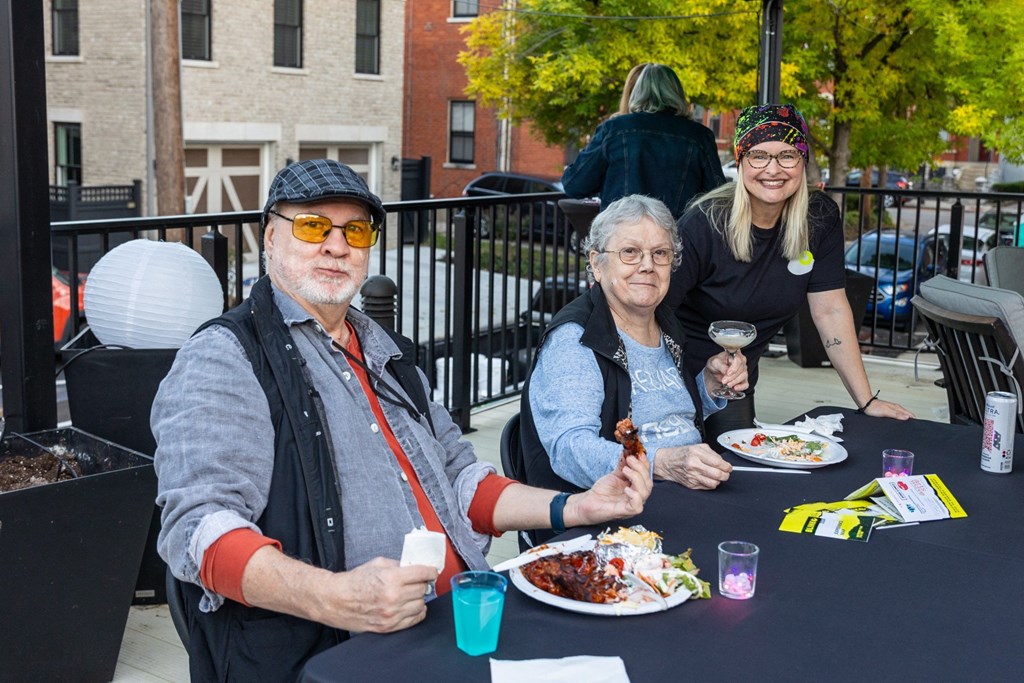 a man and two women sitting at a table eating food