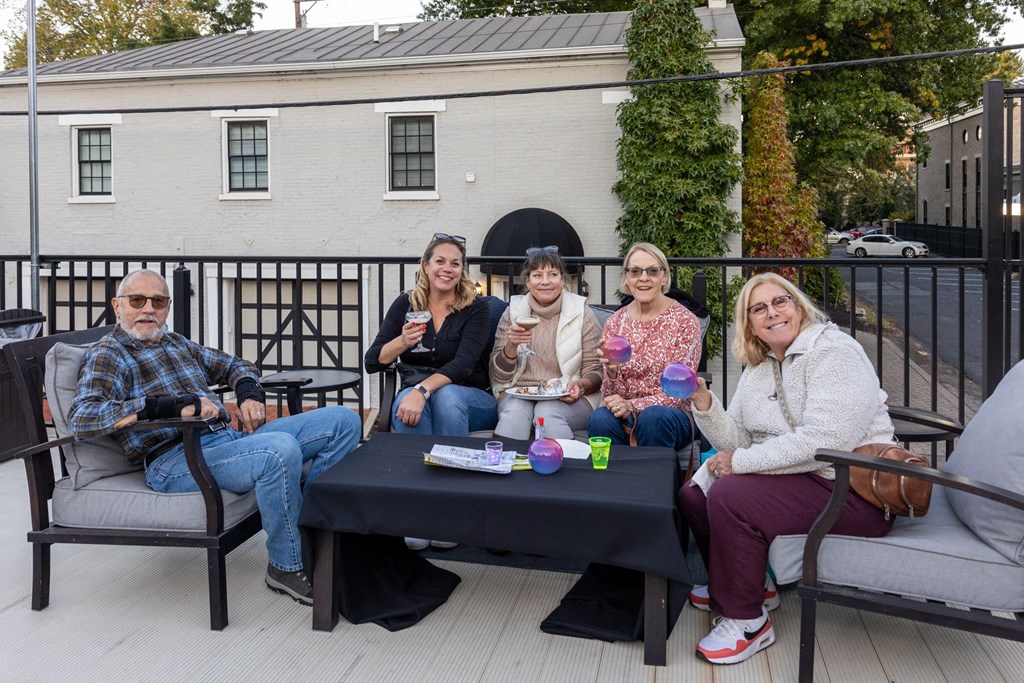 a group of people sitting around a table on a patio