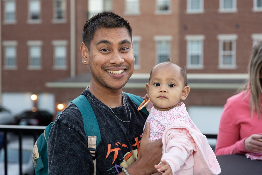 a man holding a baby and smiling at the camera
