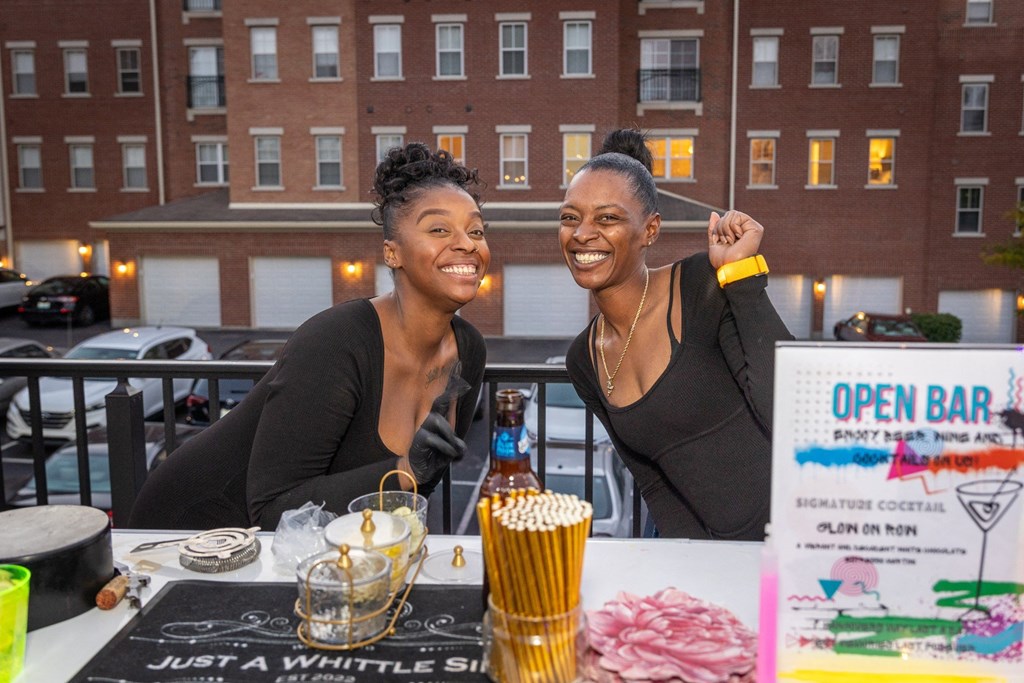 two women sitting at a table at an open bar event