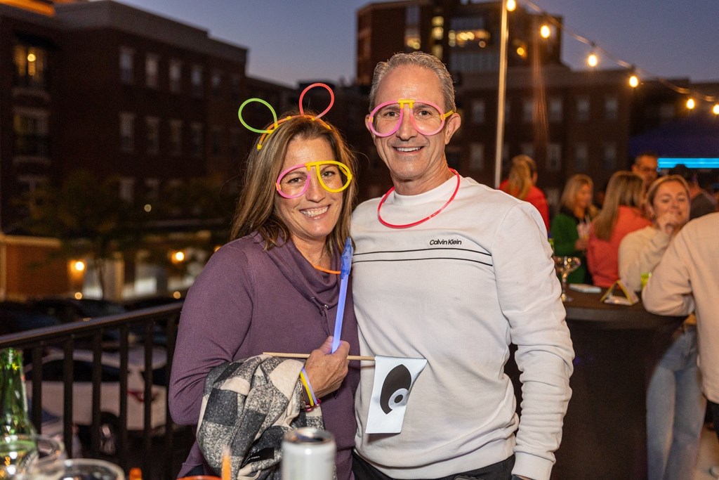 a man and a woman wearing glasses and smiling at a party