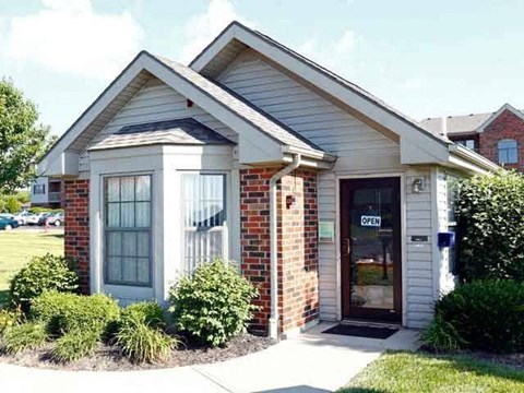 A small building with a glass door and a sign that says