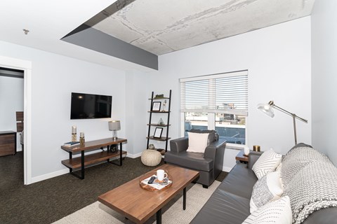 A living room with a grey couch and a wooden coffee table.