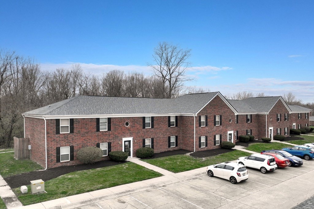 A large brick building with a parking lot in front.