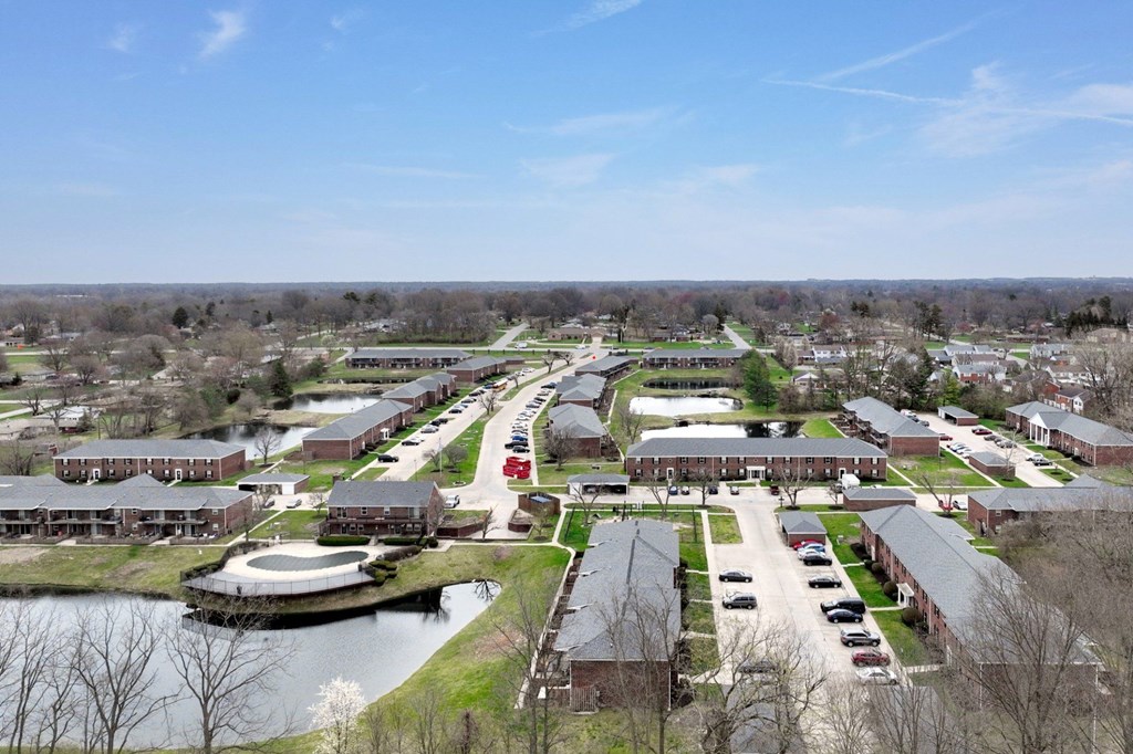 A view of a campus with a lake and buildings.
