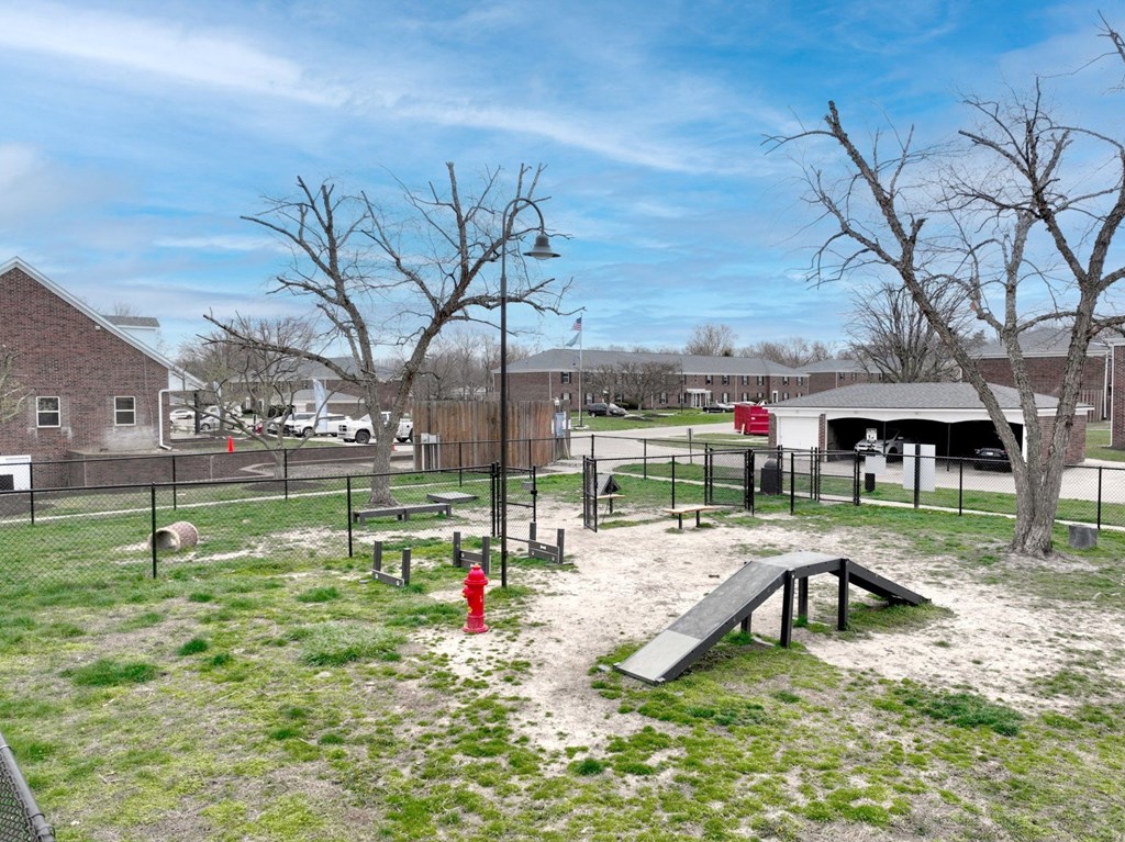 A playground with a slide, swings, and a red fire hydrant.