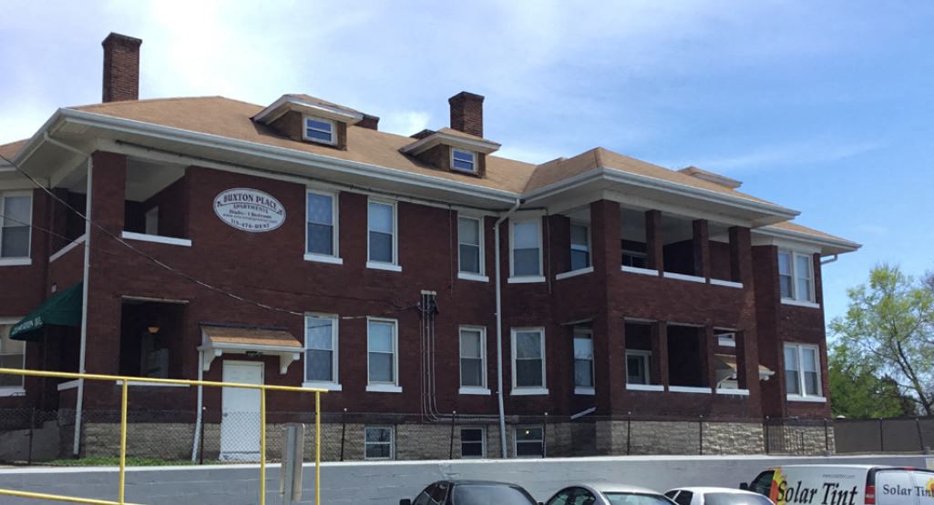 a large brick building with cars parked in front of it