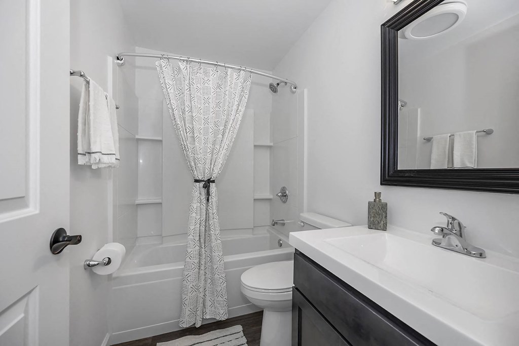 a white bathroom with a shower curtain and a sink