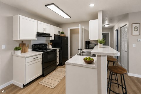 A modern kitchen with black appliances and white cabinets.