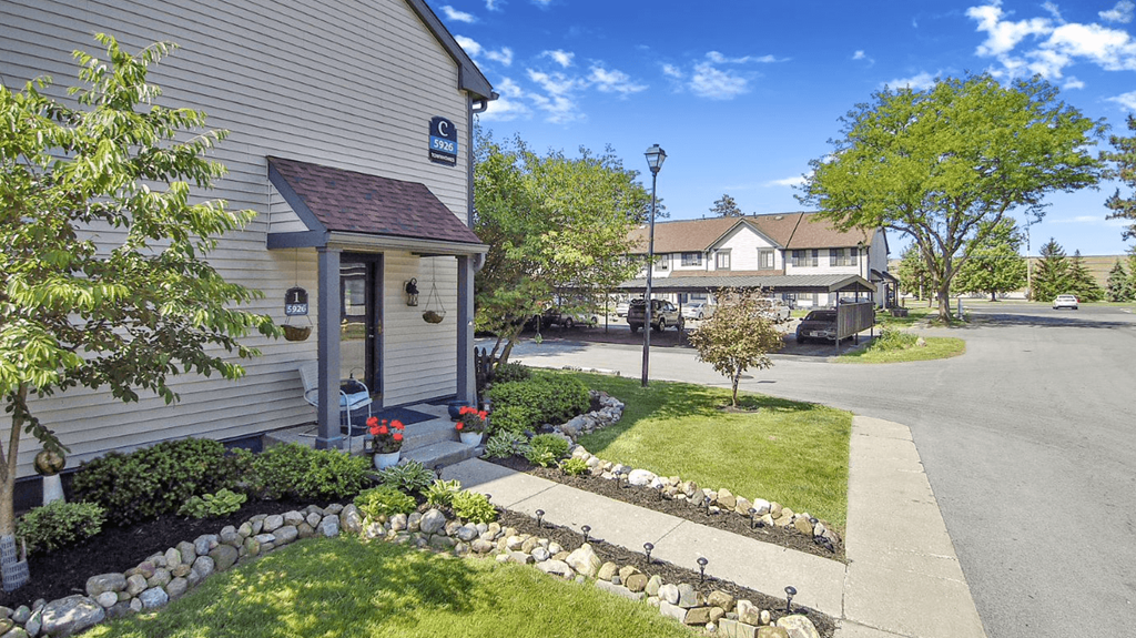 a street with a house and trees in the background