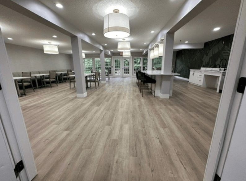 a large room with hardwood floors and white pillars