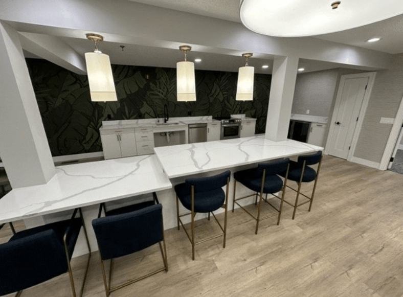 a kitchen with a long counter and a bunch of chairs