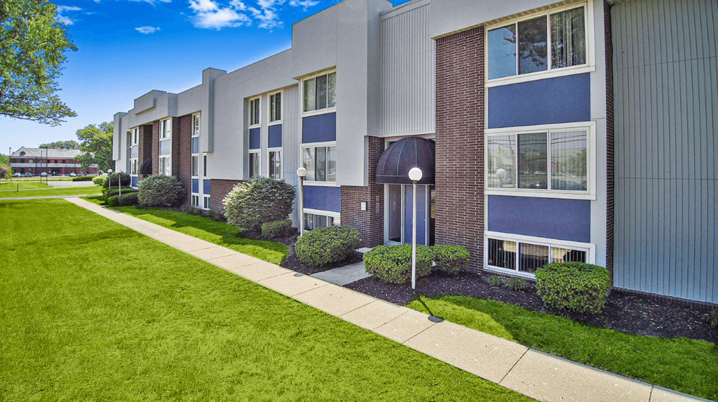 an apartment building with a sidewalk in front of it