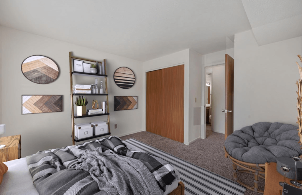 a bedroom with a bed and a chair in a 555 waverly unit at The Woodridge Collection, Ohio, 45014