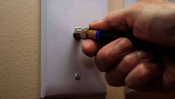 a hand holding a screwdriver to tighten a bolt on a door