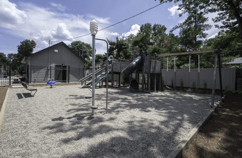 a playground with a slide and swings at Olde Towne in Kenwood, Cincinnati