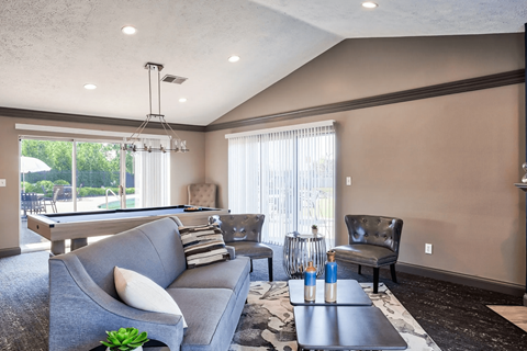 A living room with a grey couch and a black chair.