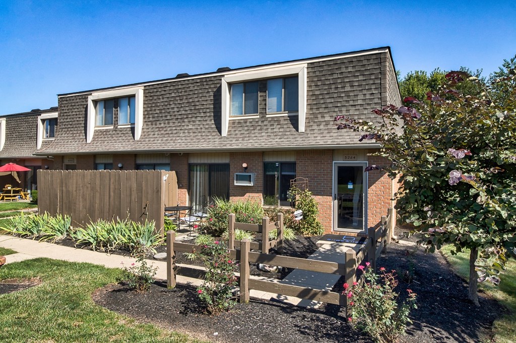 A house with a grey roof and a wooden fence.